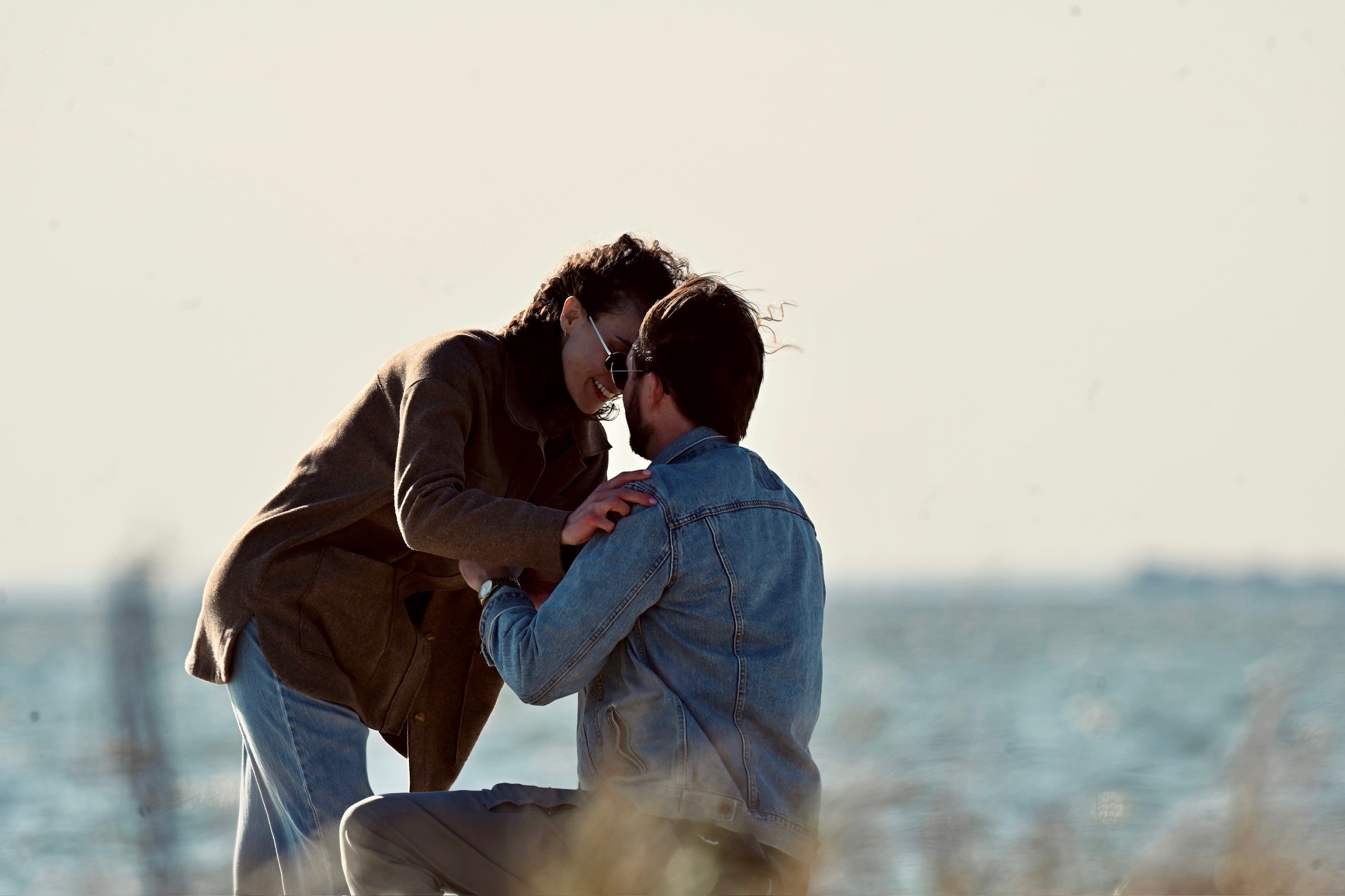 Embracing by the bay, ring on her finger